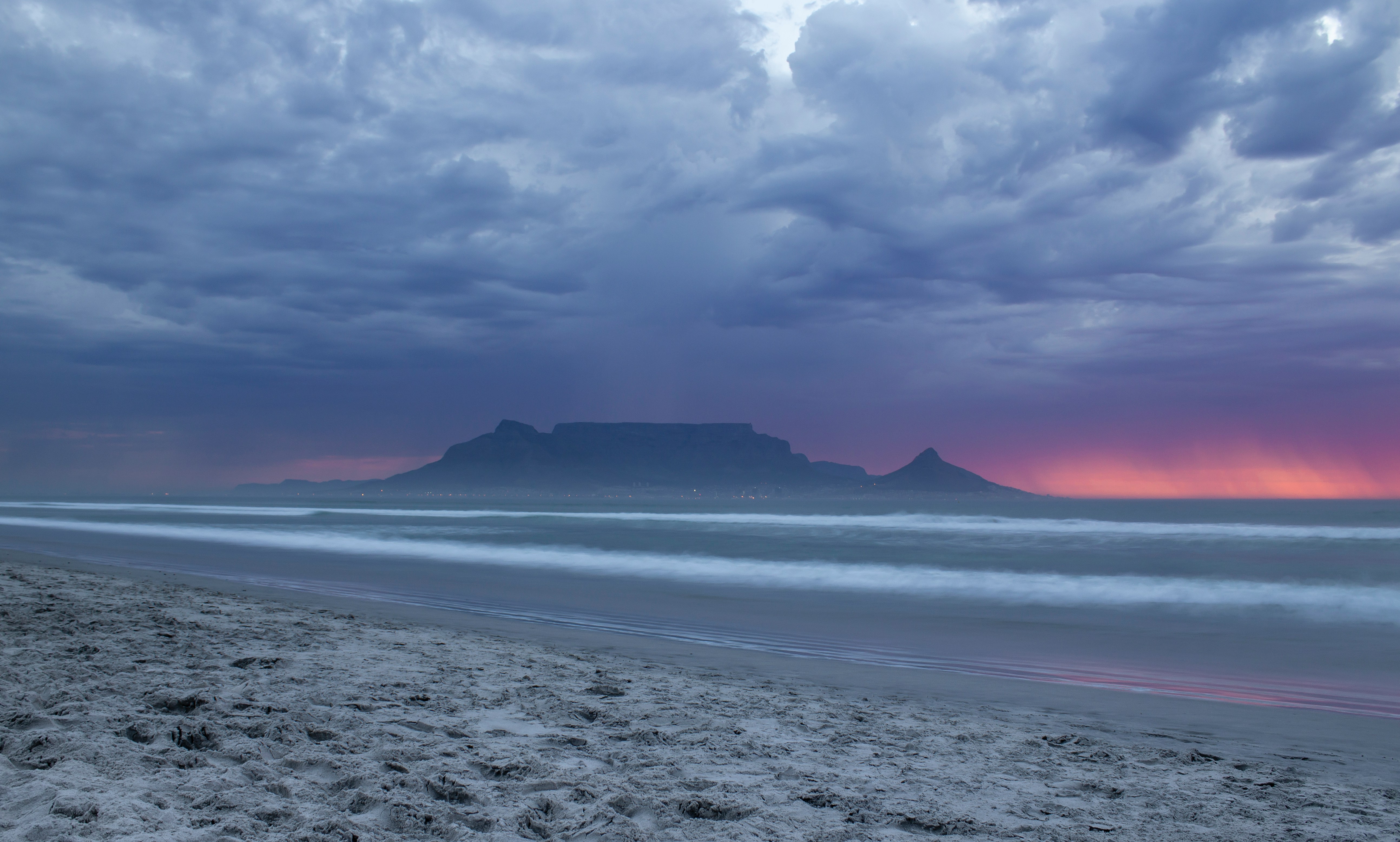 Table Mountain seen across the ocean from a Cape Town beach